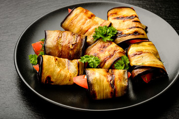 Eggplant rolls with tomatoes, garlic and dill.