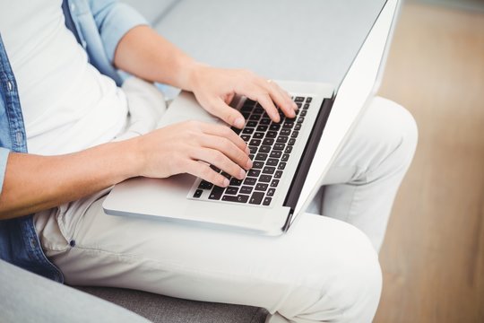 Midsection of man using laptop 