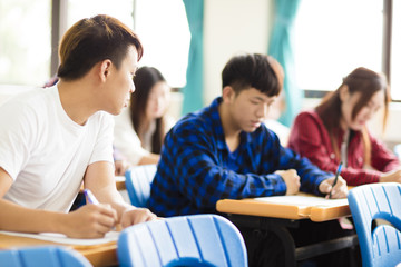 college student cheating during exam in classroom