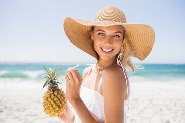 Woman drinking cocktail in pineapple