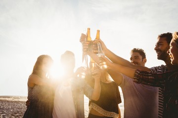 Happy friends raising beer bottles