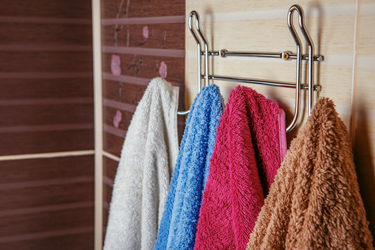 Clean Colored towels hanging on the rack in the bathroom.
