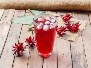 Glass of cold roselle juice on wood