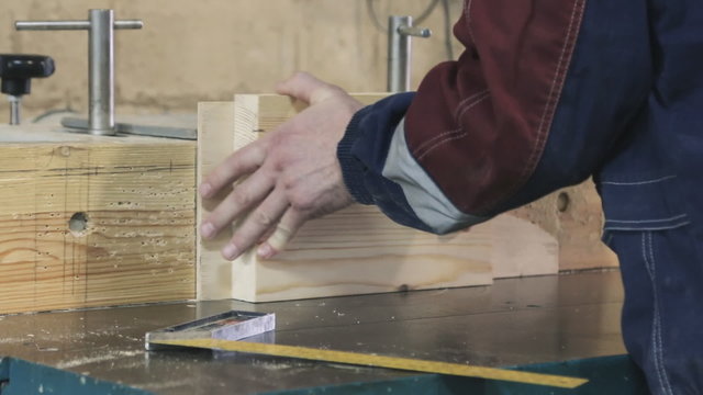 Close-up of running a board of lumber through a wood jointer power tool