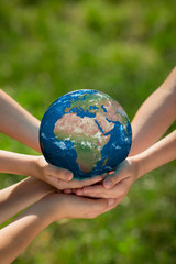 Children holding Earth planet in hands