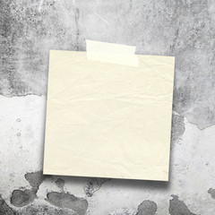 Close-up of one old blank brown paper sheet frame with adhesive tape on grey stained wall background