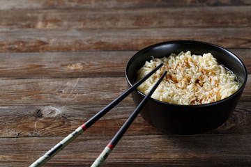 bowl of noodles with vegetables on wood table