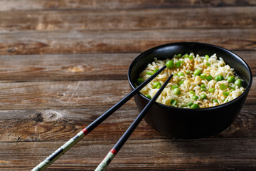 bowl of noodles with vegetables on wood table