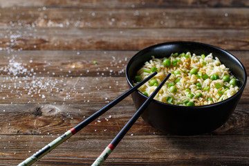 bowl of noodles with vegetables on wood table