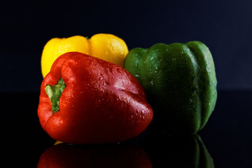 colorful peppers over dark background