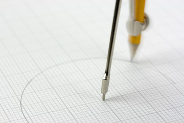 Close up of a compass on graph paper