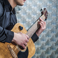 Man playing on acoustic guitar, closeup.