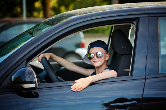 Cute little boy driving fathers car. Happy little boy sitting in the car. Stock Photo Adobe Stock