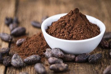 Cocoa powder on wooden background