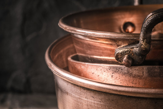 Copper Pots And Pans On The Blurred Background