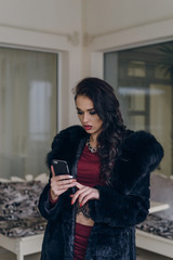 Fototapeta premium Elegant model in black coat with phone