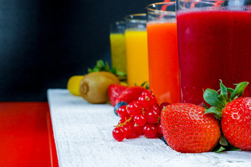 Colofrul fresh pressed fruit juices in tall glasses with fruits
