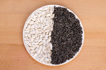 Sunflower and pumpkin seeds on a plate.