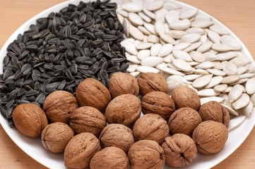 Walnuts, sunflower and pumpkin seeds on a plate.