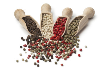 Wooden scoops with black, white,green and red peppercorns