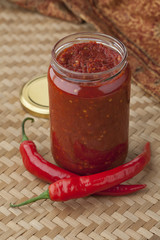 Jar with traditional Sambal and fresh red chili peppers