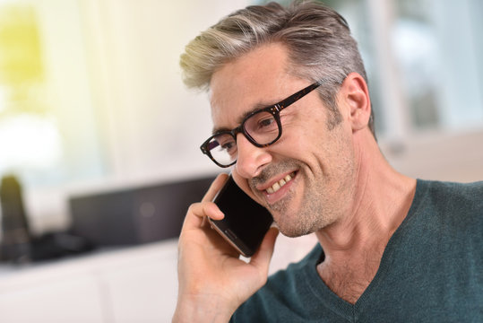 Mature handsome man with eyeglasses talking on phone