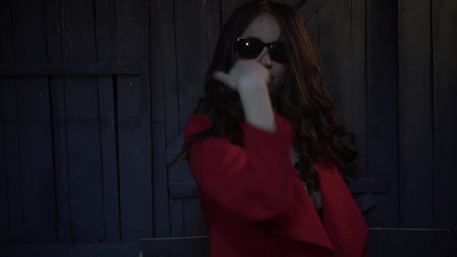 brunette girl in sunglasses with bare chest sings rap
