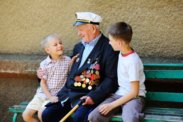 WWII veteran with children. Grandchildren looking at grandfather - obrazy, fototapety, plakaty