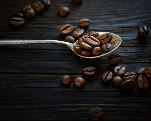 coffee beans in a spoon on a wooden background
