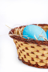 Painted eggs in basket isolated on white background.