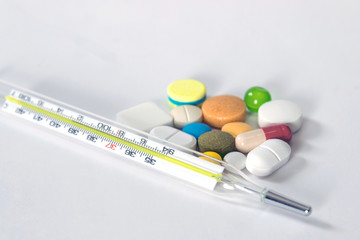 Group of medicines and thermometer isolated on white background.