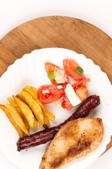 Chicken breasts and grilled red sausages on the plate