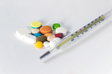 Group of medicines and thermometer isolated on white background.