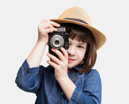 Cute little girl takes picture with vintage camera

