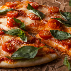 Homemade italian pizza with mozzarella, tomatoes and basil leaves.