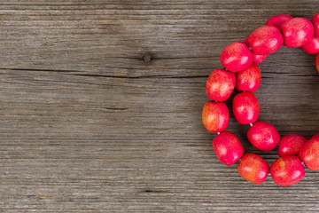 red wooden bracelet on wooden background - top view