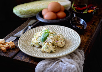 Chinese cabbage salad , oil, pepper, croutons and eggs on a wooden background