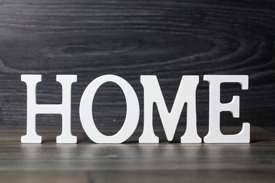 White letters with word HOME on wooden surface