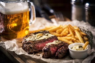 Foto op Plexiglas Gezonde mager gegrilde medium-rare steak met frietjes, bier © nazarovsergey