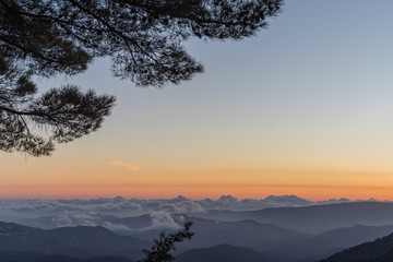 Panoramic view on mountain range with layer mist on evening glow background. Troodos, Cyprus.
