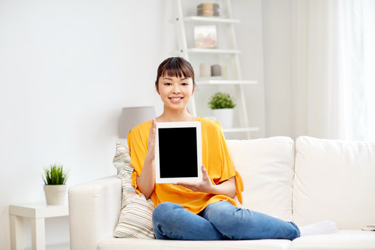 happy young asian woman with tablet pc at home