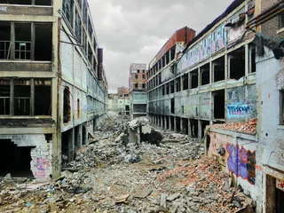 Fototapeten Verlassene Gebäude Detroit verlassenes Fabriklager zerbröckelt in Apokalypse - Landschaftsfarbfoto  © jryanc10