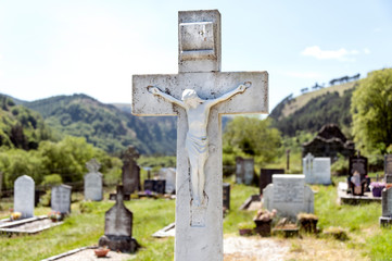 Irish graveyard with Jesus on a white cross and hills in the background