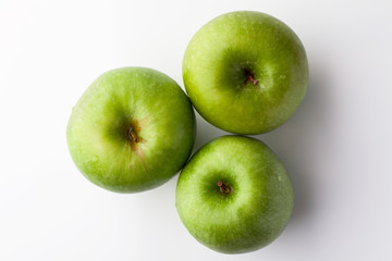 Three green fresh ripe apple on white background directly from above
