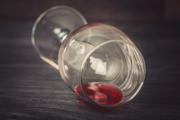 Fallen wine glass with red wine on wooden background