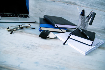 Stylish modern workspace work desktop with diary notebooks glasses on the wooden vintage table background wide angle