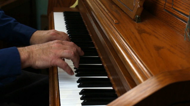 Older Male Hands Playing Upright Piano From The Side
