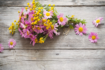 bouquet of pink and yellow flowers on wooden background