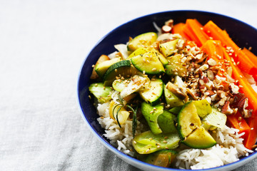 Gemüsepfanne mit Reis, Veganes Mittagessen - Pilze, Zucchine, Poree, Möhren, Sesam und Nüsse, bowl mit Gemüse