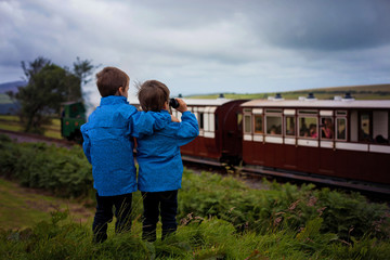 Two boy, looking at old steam train